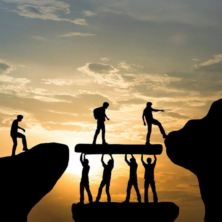 Силуэты людей, удерживающих платформу, чтобы другие могли пройти над пропастью